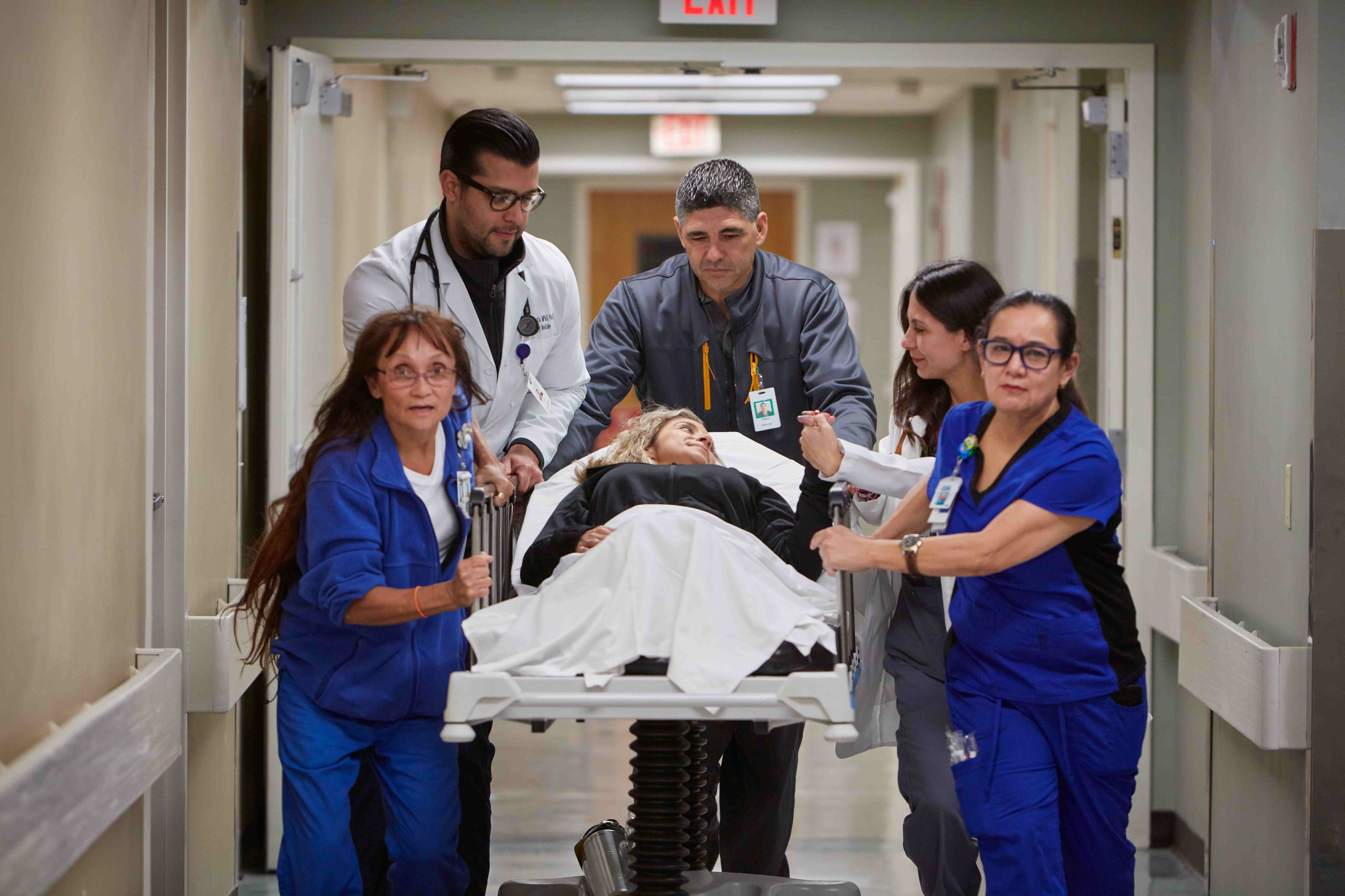 Hospital care team transporting patient on gurney