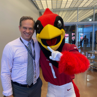 Person posing with the Arizona Cardinals mascot