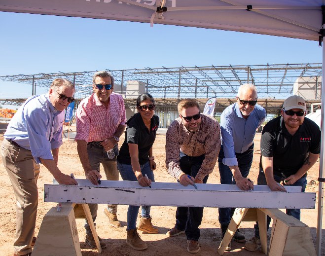 Group signing commemorative beam at event