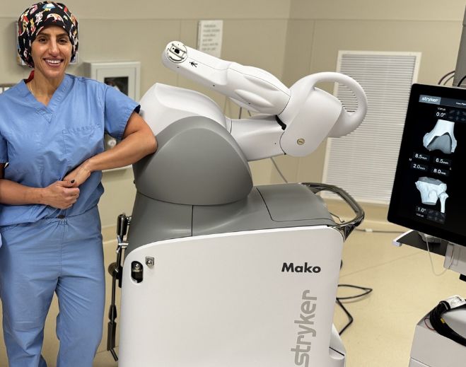 Clinician standing beside MAKO robotic surgery system