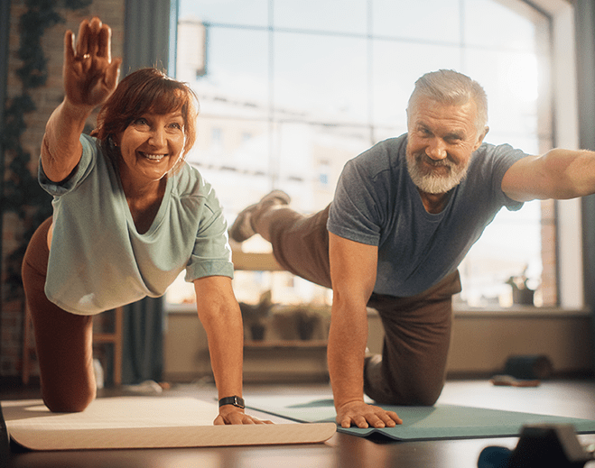 Two adults exercising on yoga mats