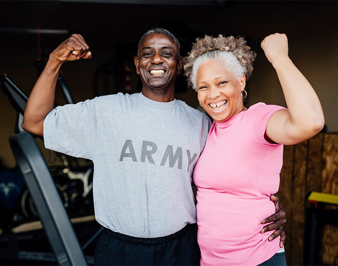 Two adults flexing arms in gym