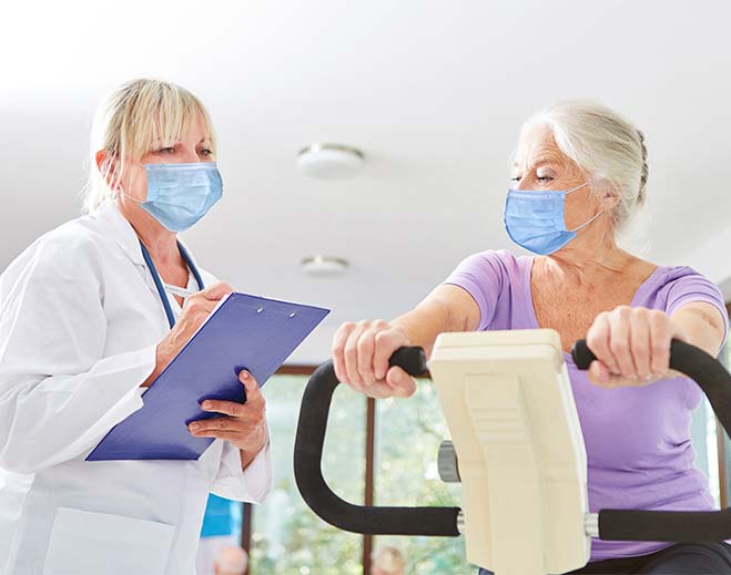 Person exercising on stationary bike with clinician