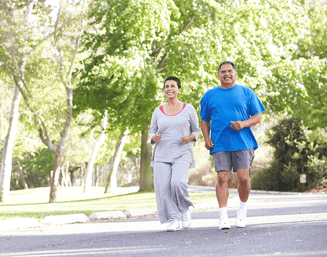 Two people jogging on tree lined path